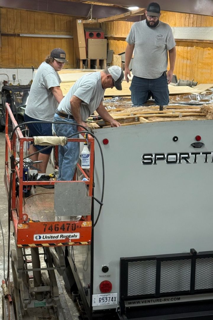 RVIA-certified technician servicing rooftop AC unit